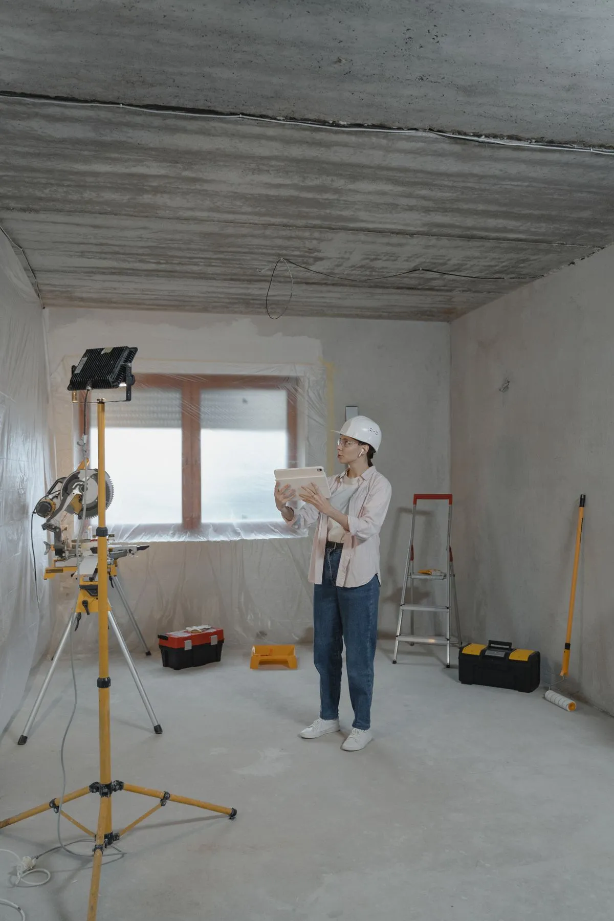 Professionnel portant un casque consultant l'application sur une tablette sur le chantier