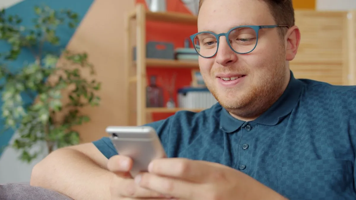 Customer smiling while following the service on a phone at home