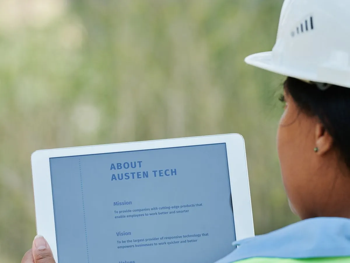 A construction worker checking the project plans on a tablet at the job site